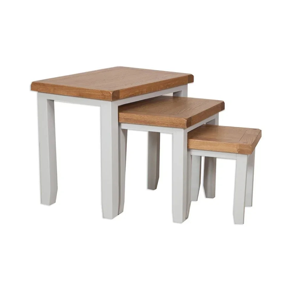 Set of three oak nesting tables with white painted legs on white background