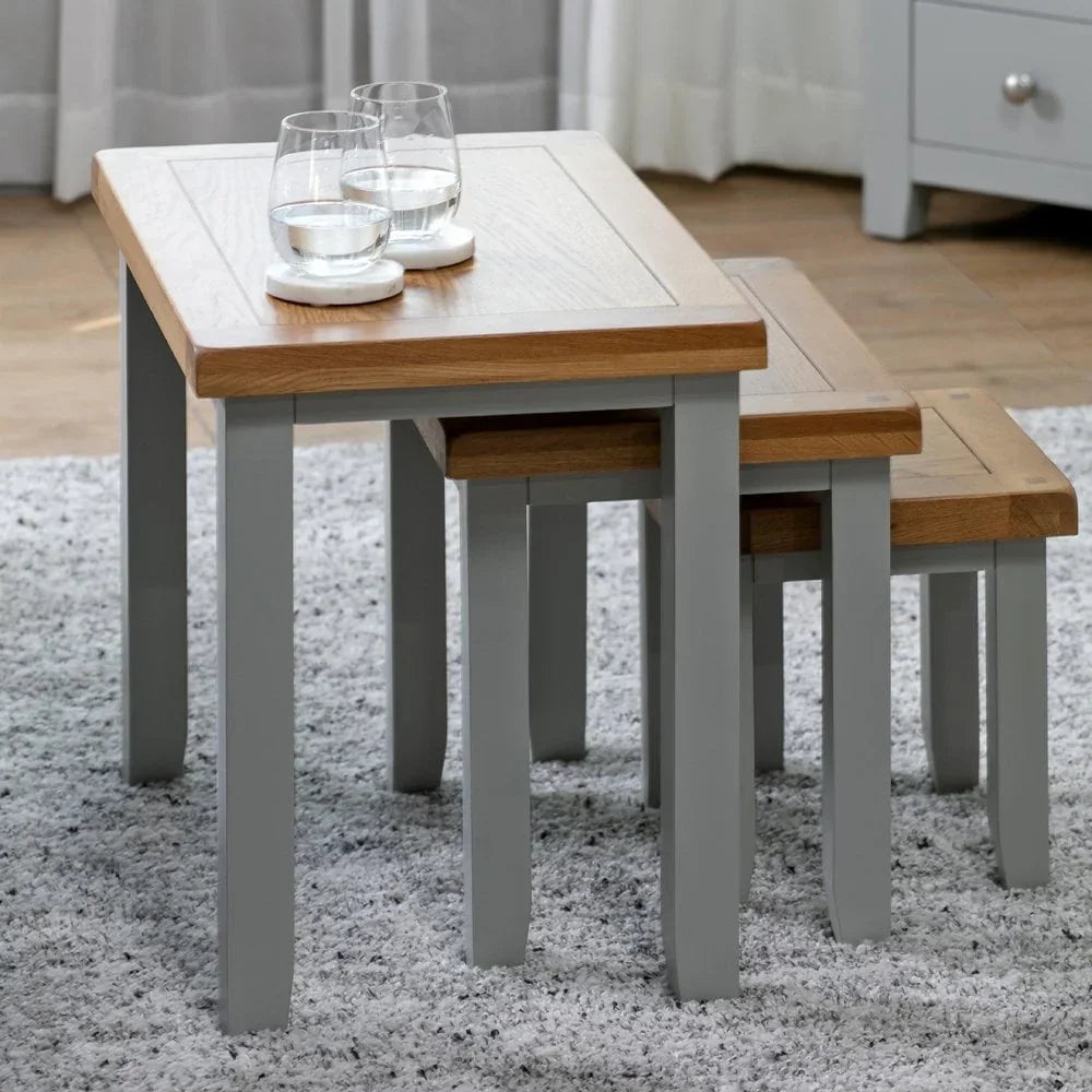 Oak and grey nest of tables with glass tumblers on living room rug
