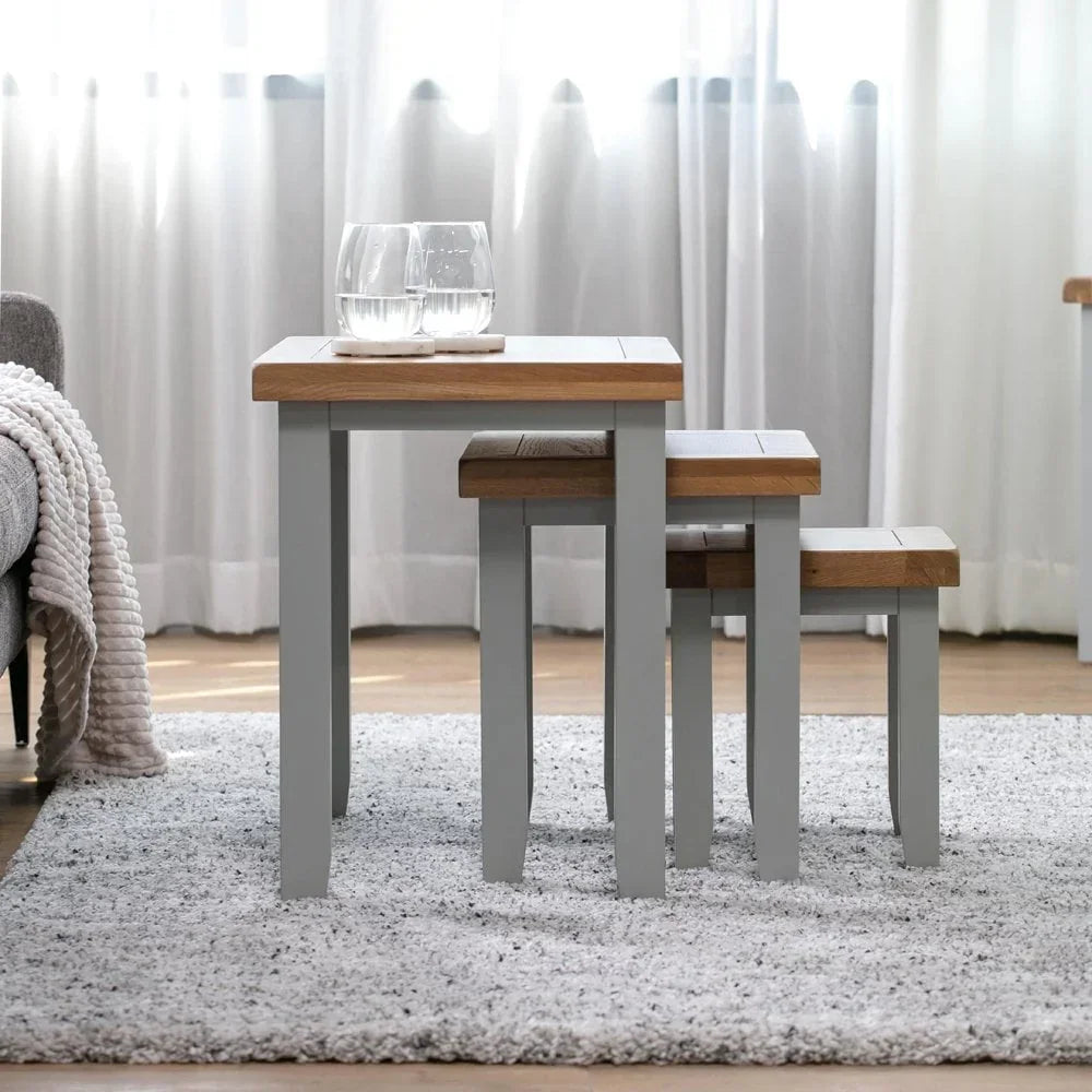 Oak and grey nest of tables in living room, set of three, with glasses on top