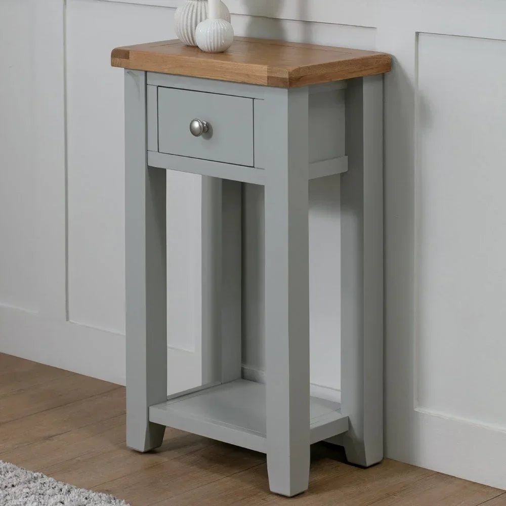 Grey console table with oak top, single drawer and lower shelf against white wall