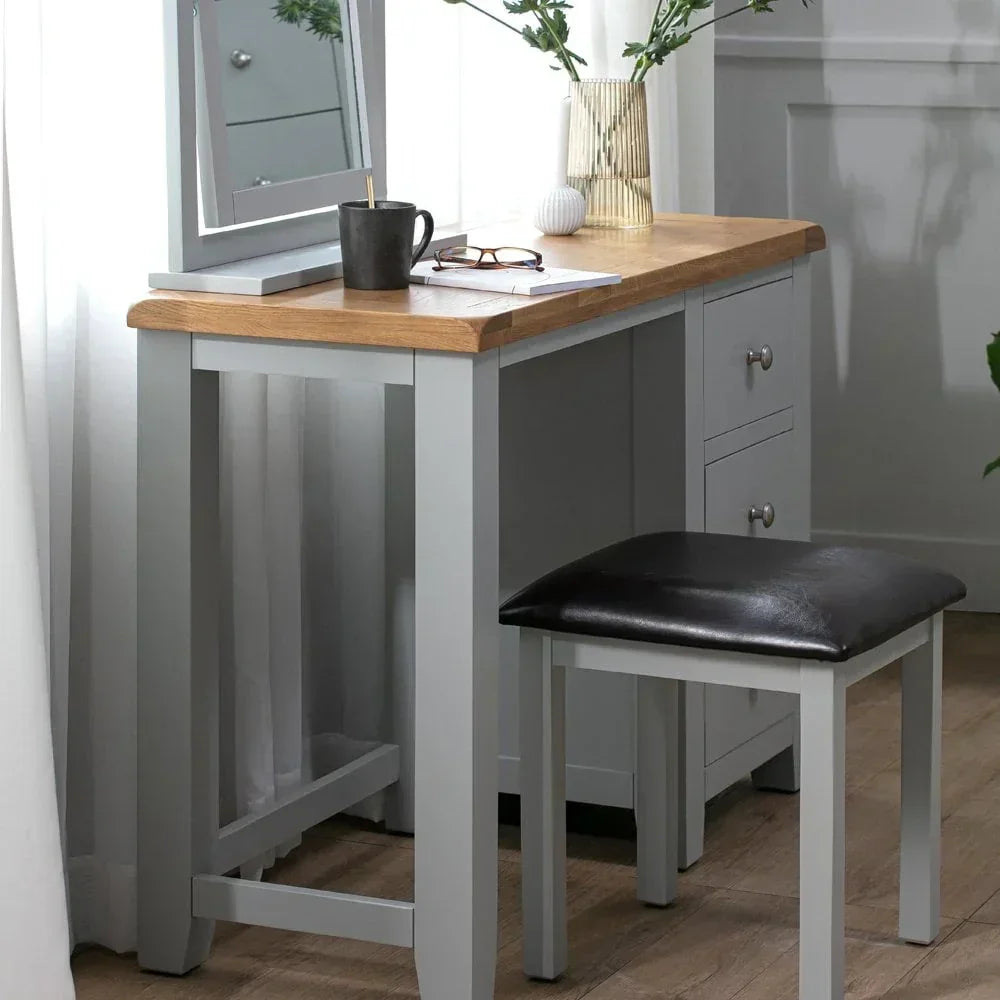 Grey wooden dressing table with oak top, black stool, mirror, drawers and vase