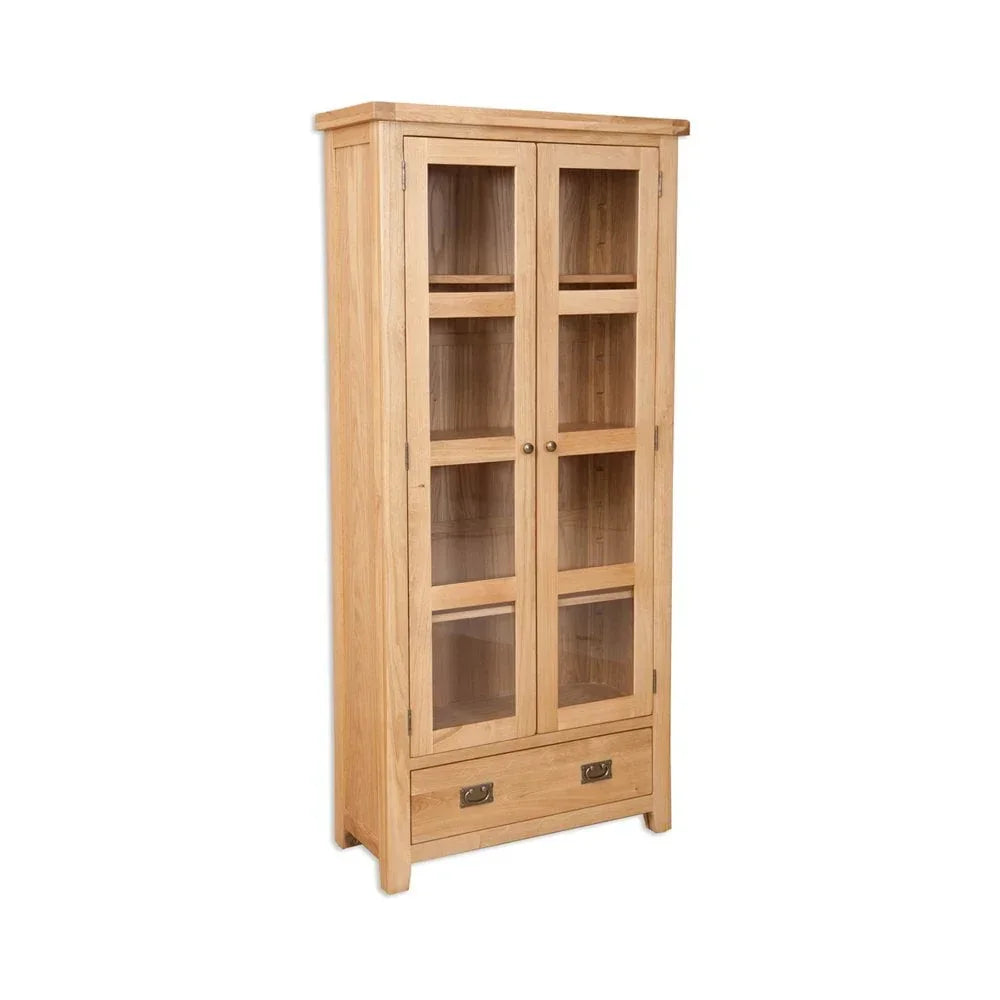 Oak display cabinet with glass doors and lower drawer, shown at an angle on white background