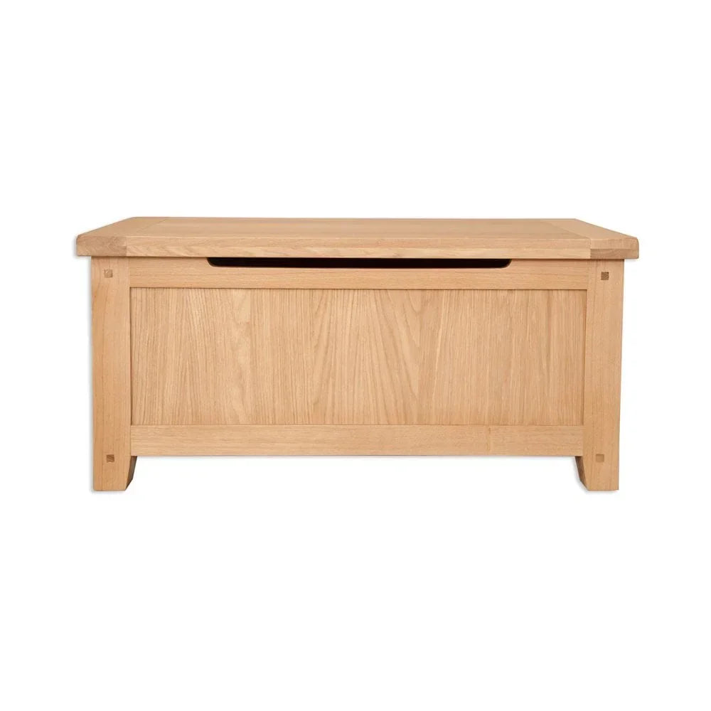 Oak storage chest with panelled front and lift-top lid on a white background