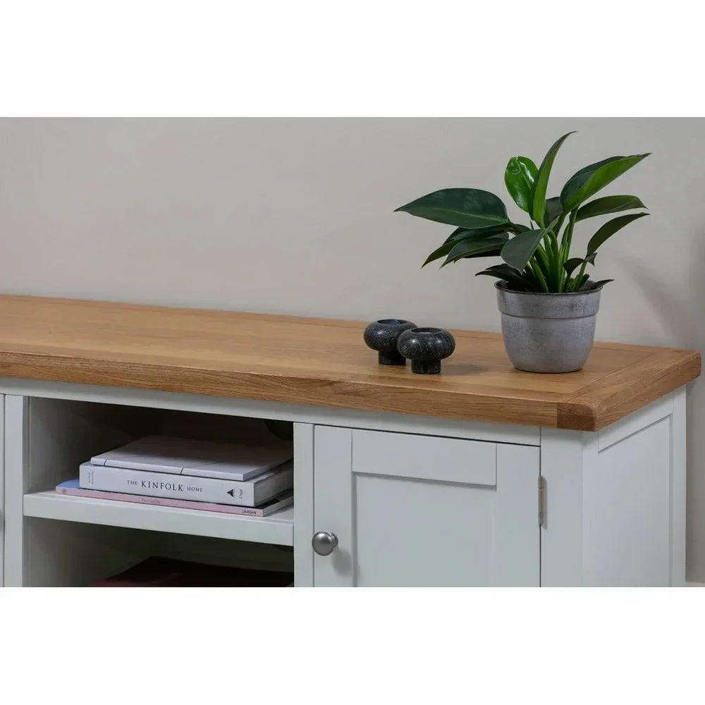 White sideboard with oak top, potted plant, and decorative books on shelf