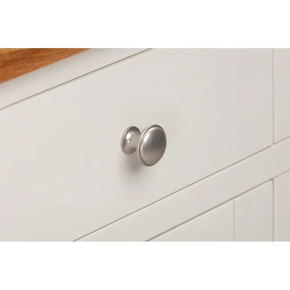White cabinet drawer with silver metal knob and wood countertop detail