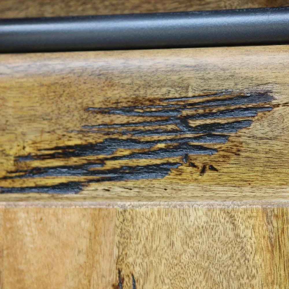 Close up of rustic wooden furniture surface with distressed finish and black metal handle
