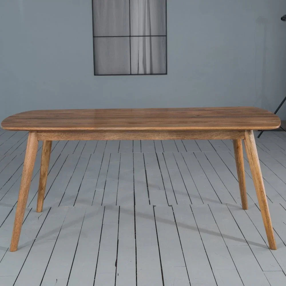Rectangular wooden dining table with angled legs on painted wood floor