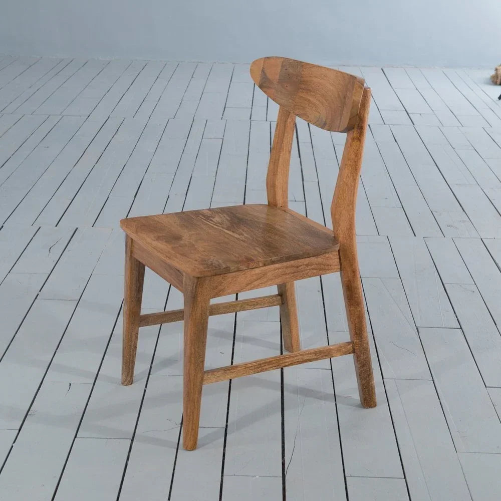 Solid wood dining chair with curved backrest on light painted floor