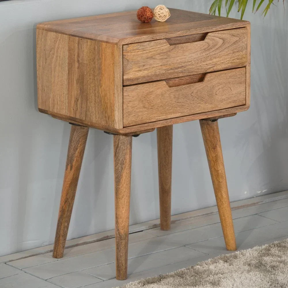Solid wood bedside table with two drawers and angled legs on wooden floor