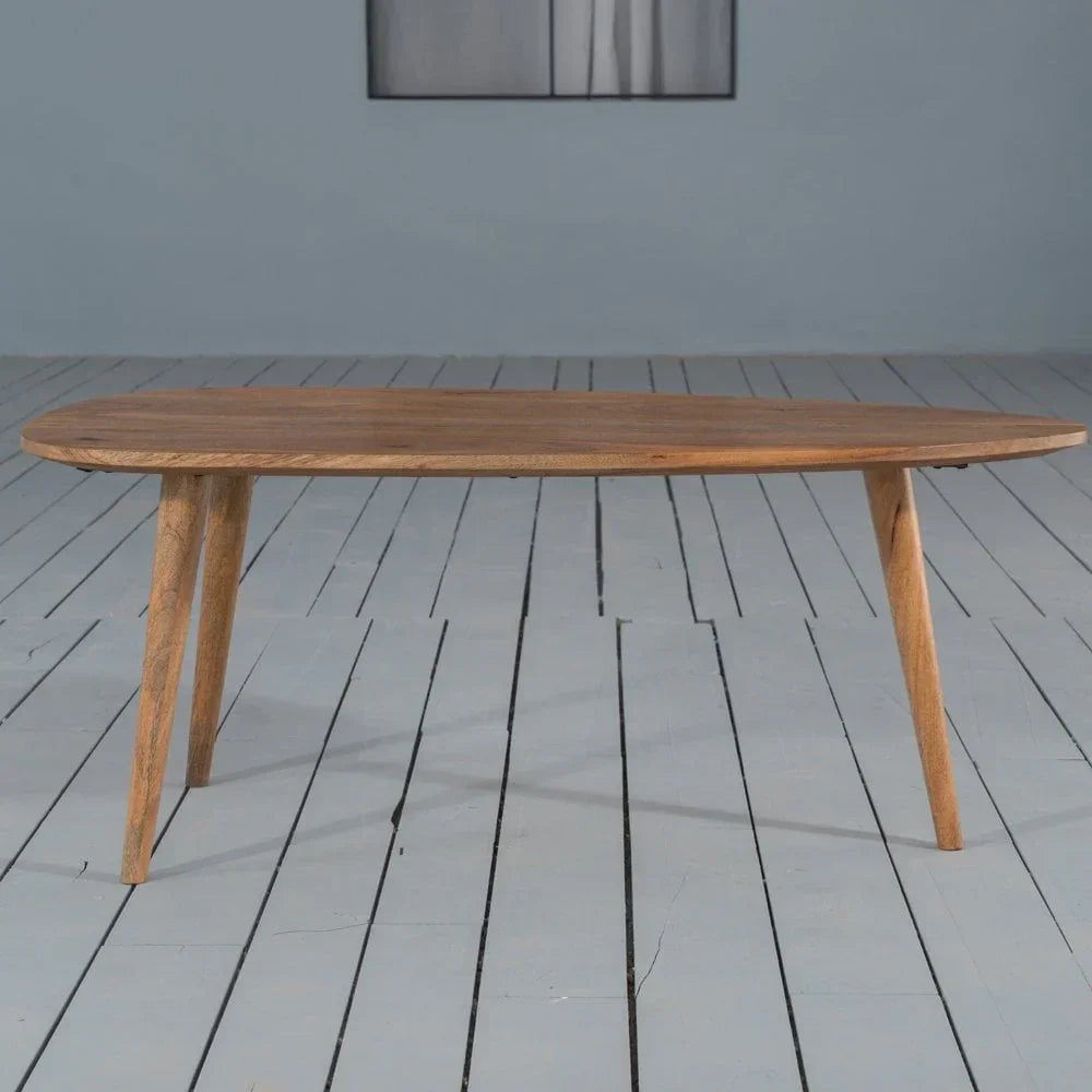 Oak coffee table with rounded edges and angled legs on painted wood floor