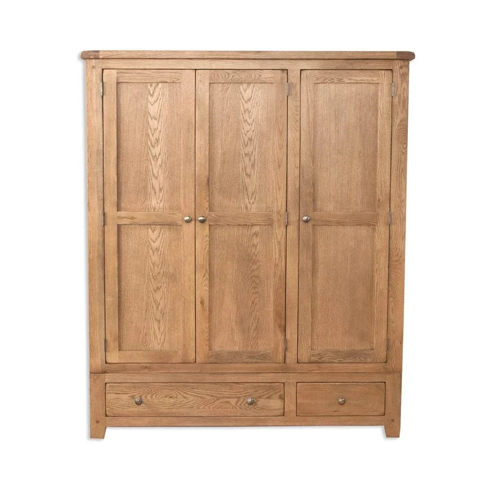 Oak wardrobe with three doors and two lower drawers on white background