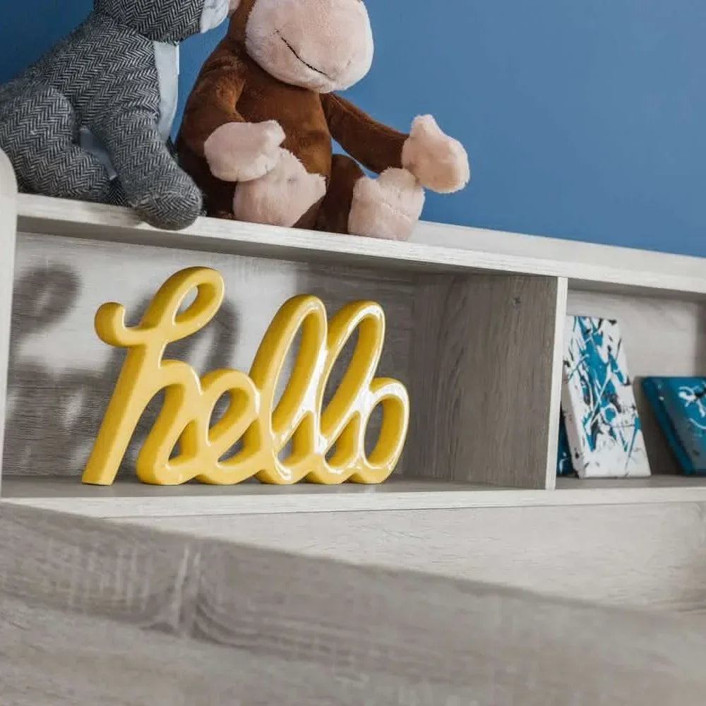 Wooden shelf with plush toys, yellow hello sign, and abstract blue wall art