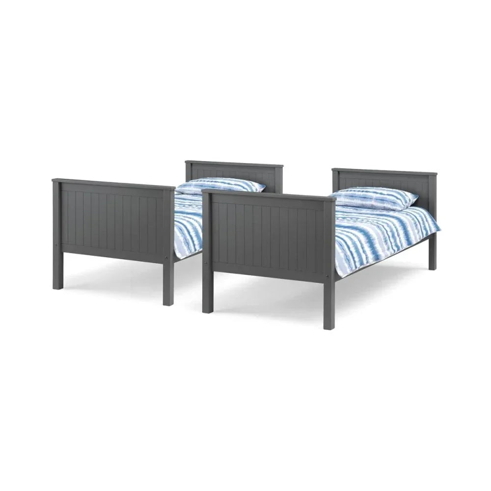 Pair of grey wooden single beds with striped blue bedding, shown from footboard angle