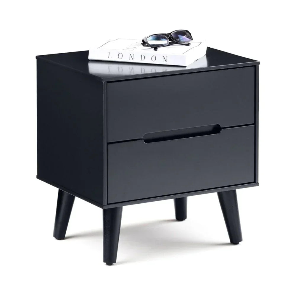 Black bedside table with two drawers and angled legs, book and sunglasses on top