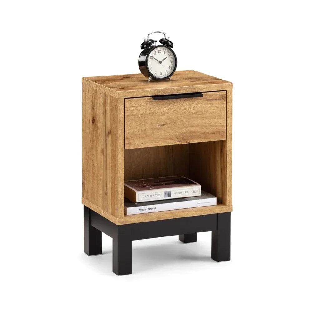 Oak bedside table with drawer, black legs, and shelf holding books, clock on top