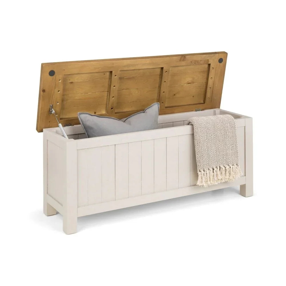 Wooden storage bench with hinged lid, cushion and throw inside, white panel finish