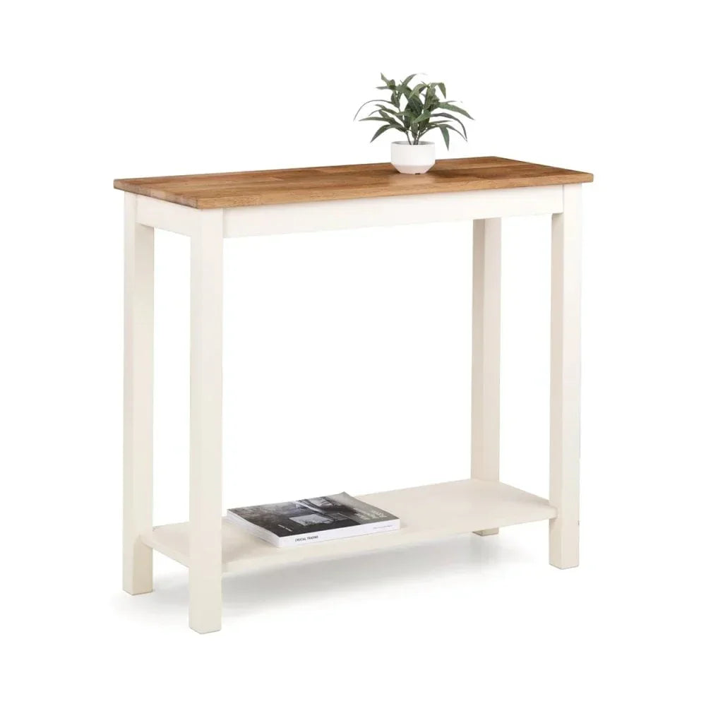 White console table with wood top, lower shelf, potted plant, and magazine