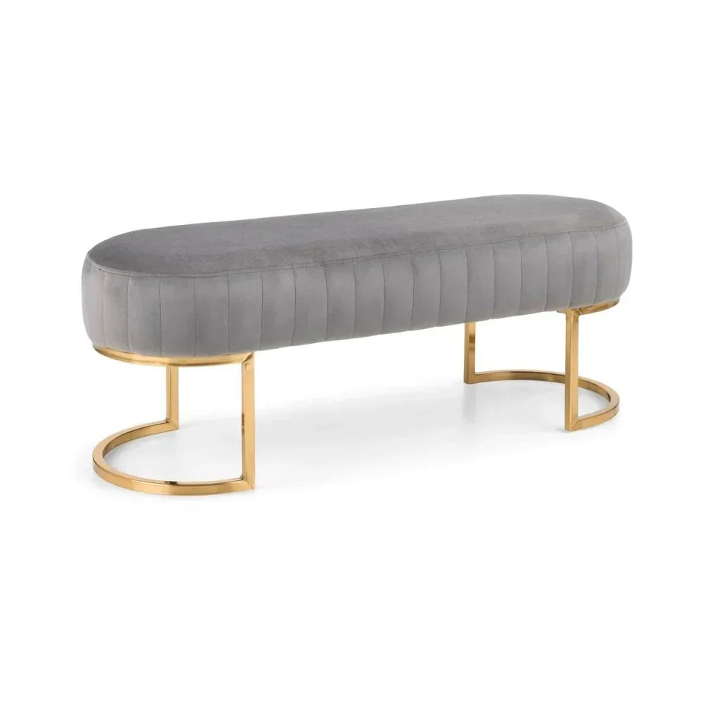 Grey velvet bench with gold metal legs, upholstered seat, side angle view