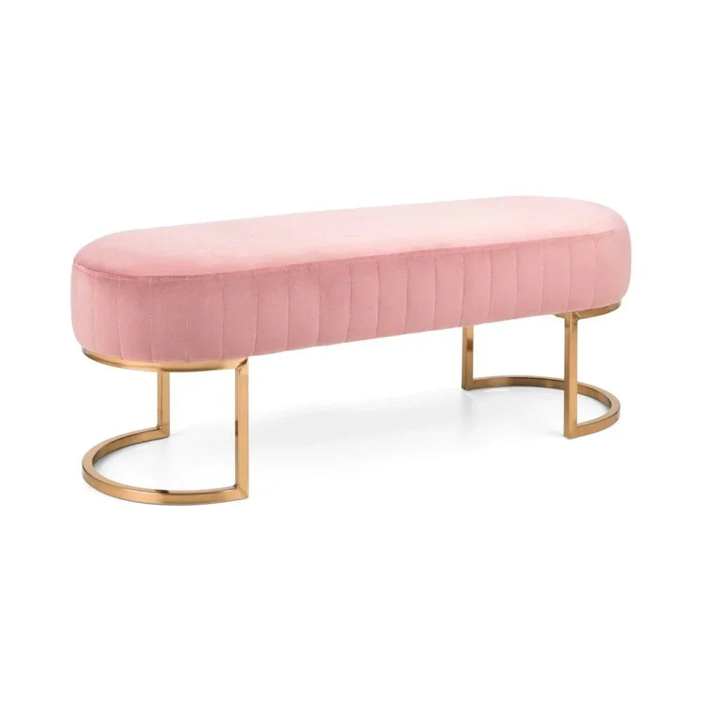 Pink velvet bench with gold metal legs and rounded edges on white background