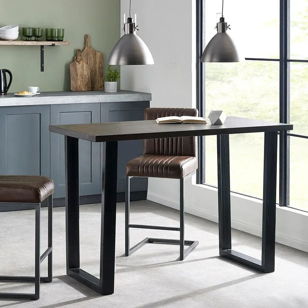 Modern dining table with brown leather bar stools and black metal legs in kitchen setting