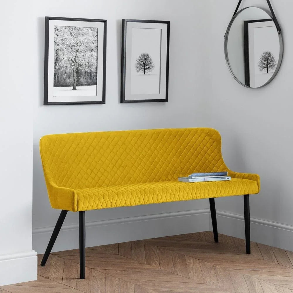 Yellow velvet bench seat with quilted detail and black legs in a modern hallway setting