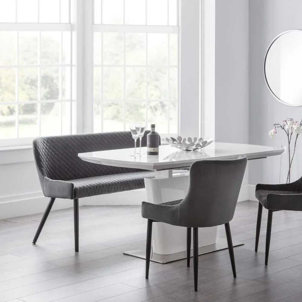 Modern dining table set with grey velvet chairs and bench in bright room