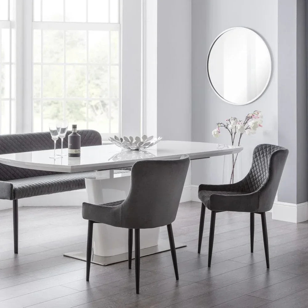 Grey velvet dining chairs and bench around white gloss dining table in modern room