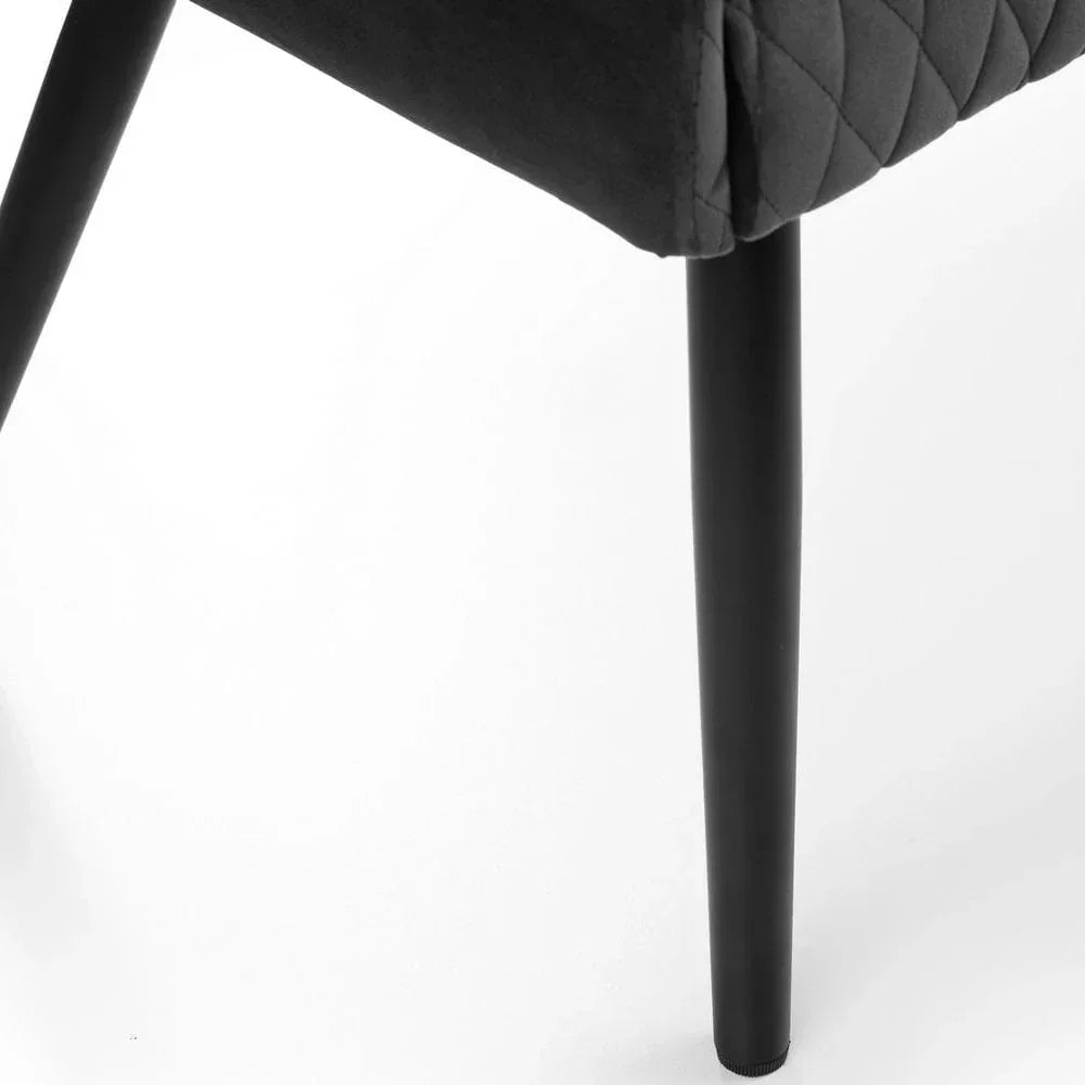 Close-up of black quilted chair upholstery with slim black metal leg