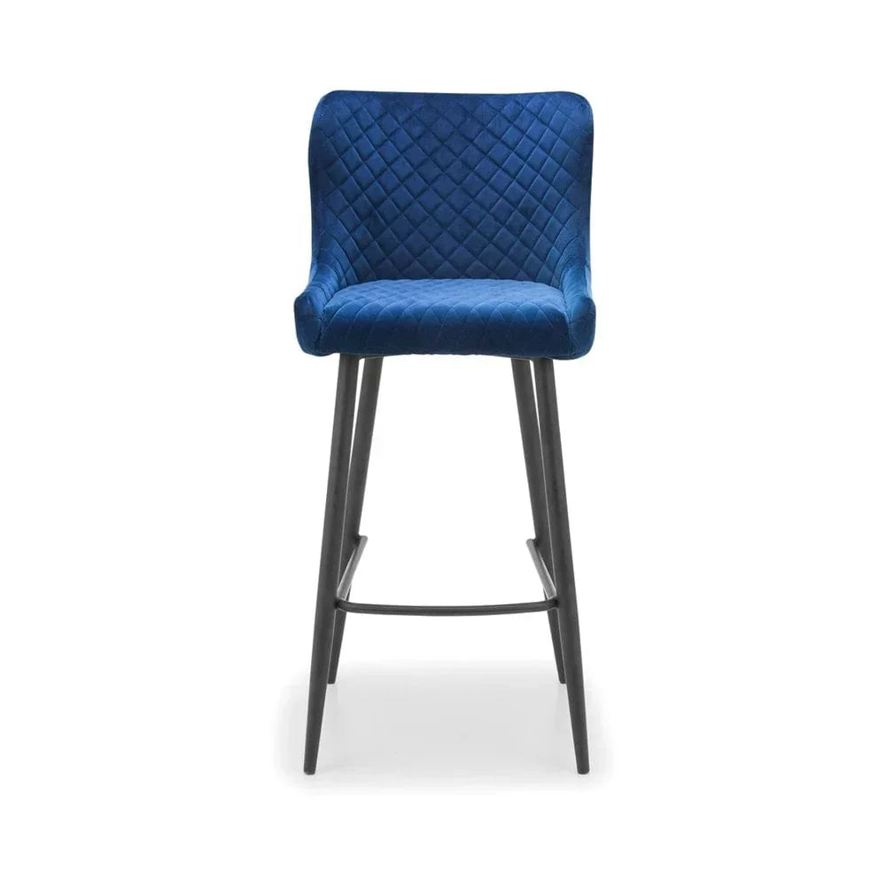 Blue velvet bar stool with quilted backrest and black metal legs, front view
