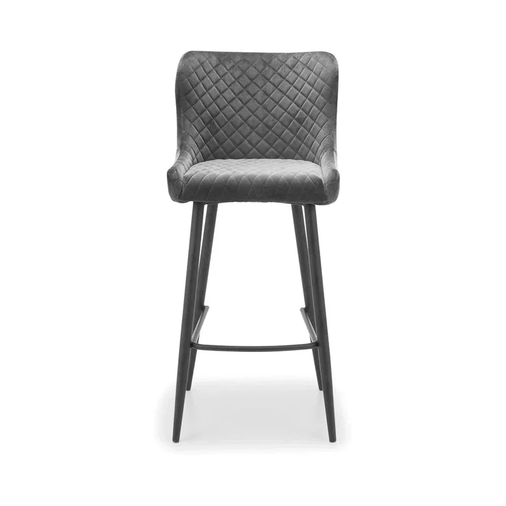 Grey velvet bar stool with quilted seat and backrest on black metal legs, front view
