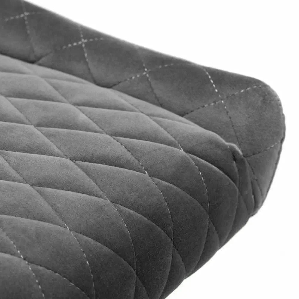 Close-up of grey quilted velvet dining chair seat with diamond stitch pattern