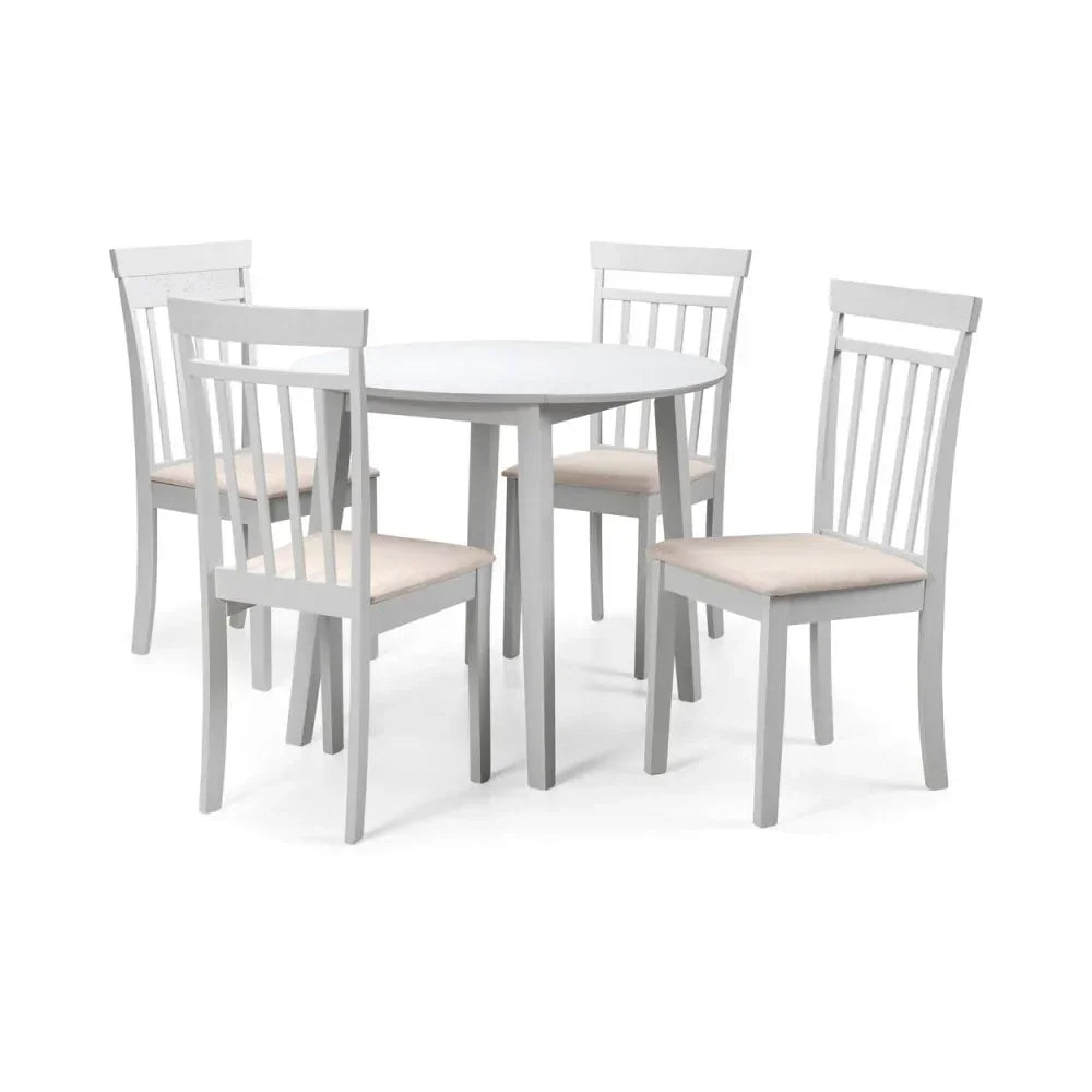White wooden dining table set with four slatted back chairs and cream seat cushions