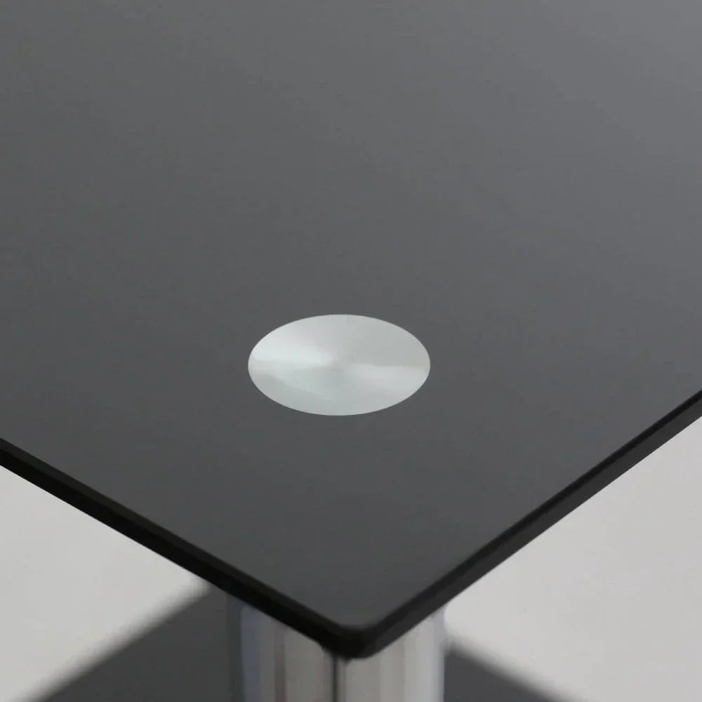 Corner of black glass dining table with chrome leg detail