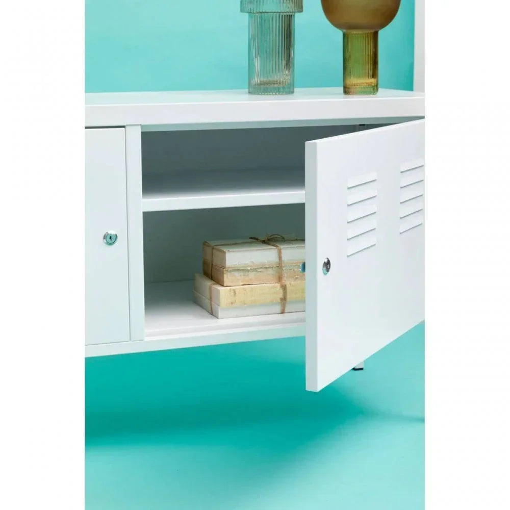 White storage cabinet with open door, visible shelf, and stacked books on turquoise floor