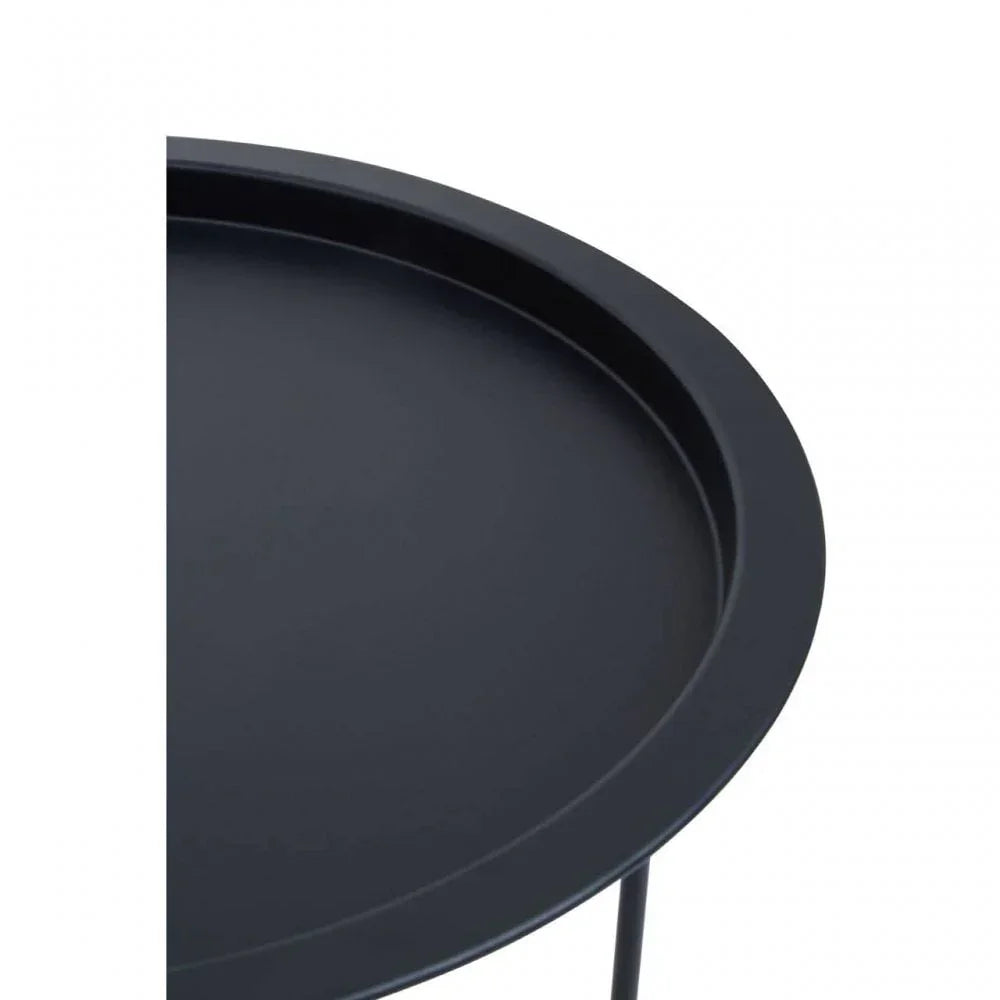 Closeup of round black metal side table with raised edge on slim legs