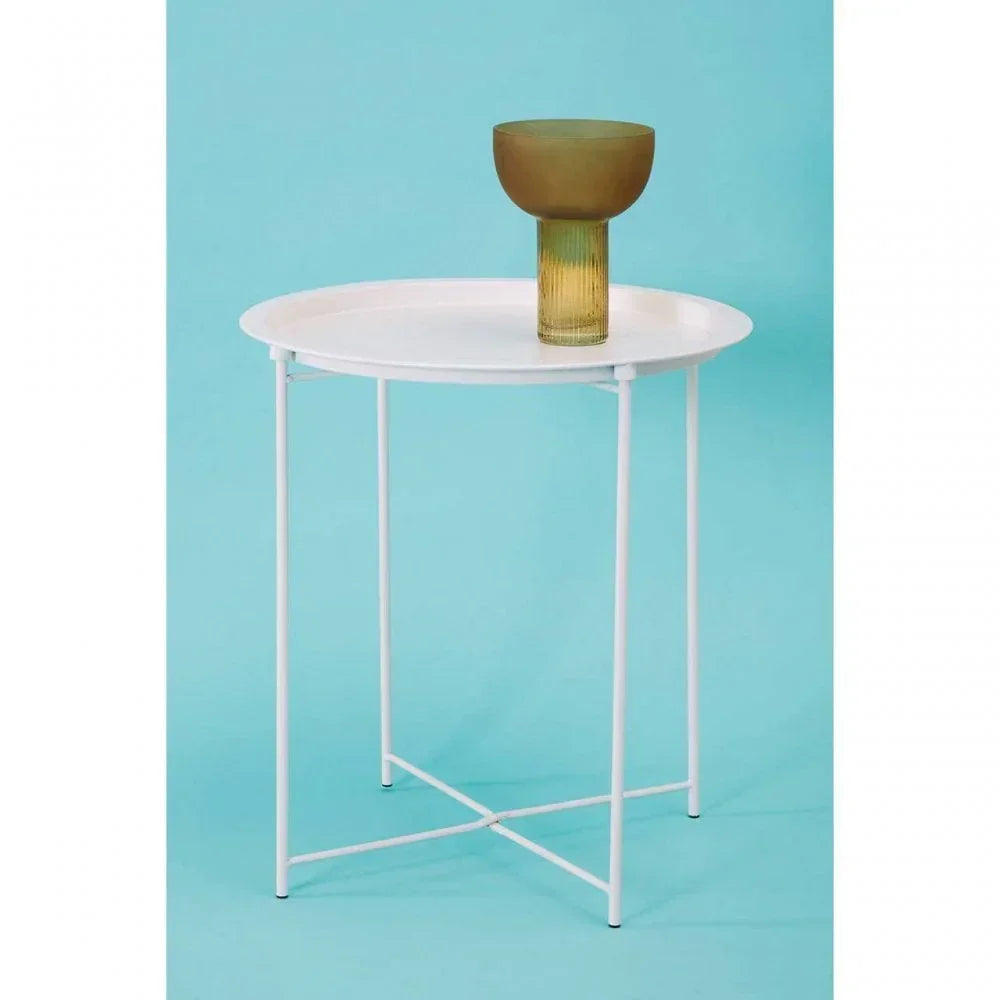 Round white side table with metal legs, green glass vase on top, blue background