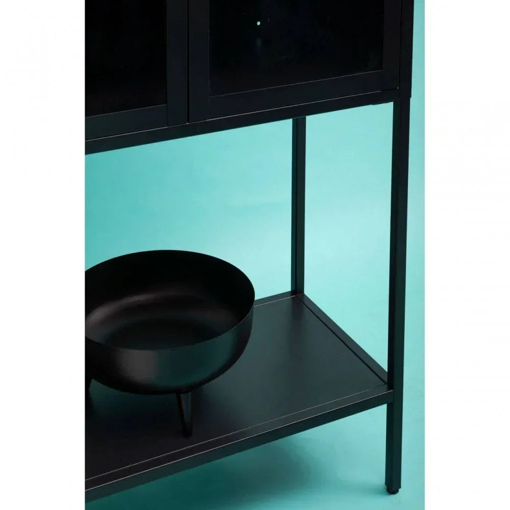 Black metal storage shelf with bowl on lower tier against teal background