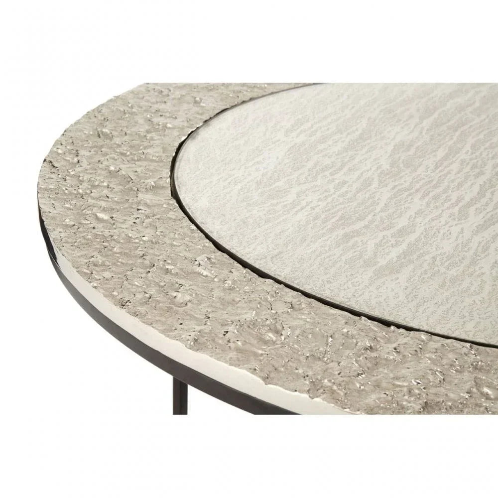 Round textured metal and glass coffee table top, close view showing surface detail
