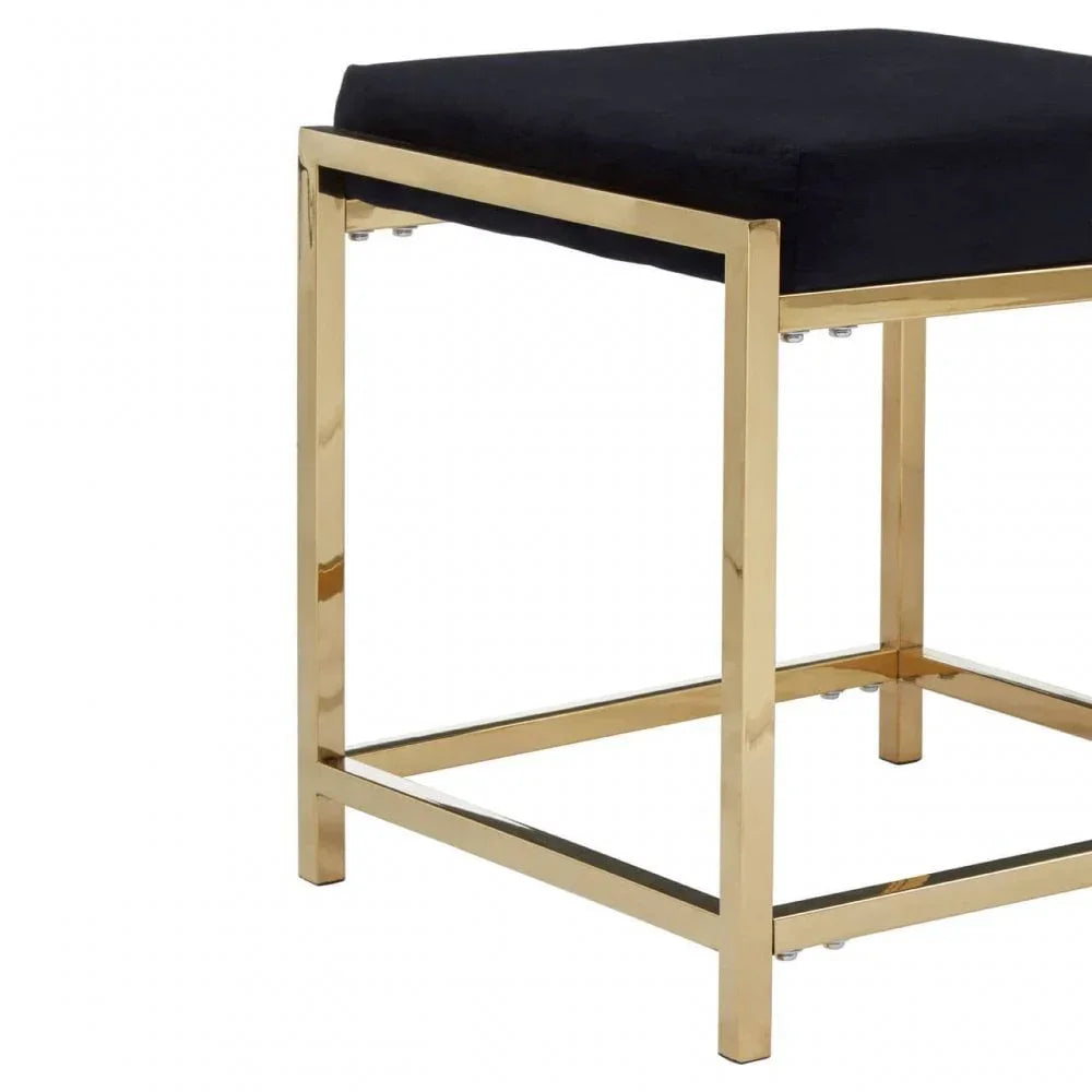 Black velvet stool with gold metal frame, close view of seat and modern legs