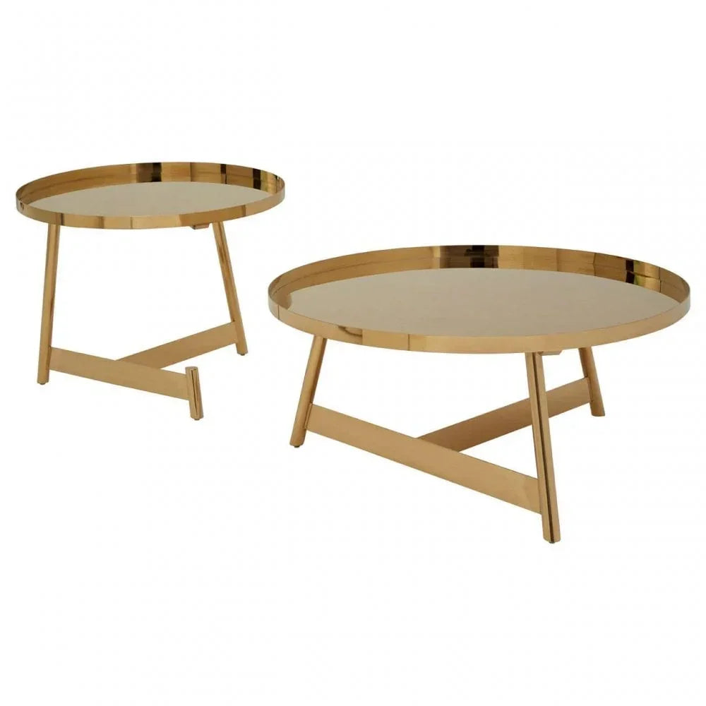 Round gold metal coffee tables set with crossed legs on white background