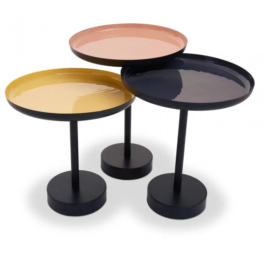 Set of three round metal side tables with pink, yellow, and black tray tops