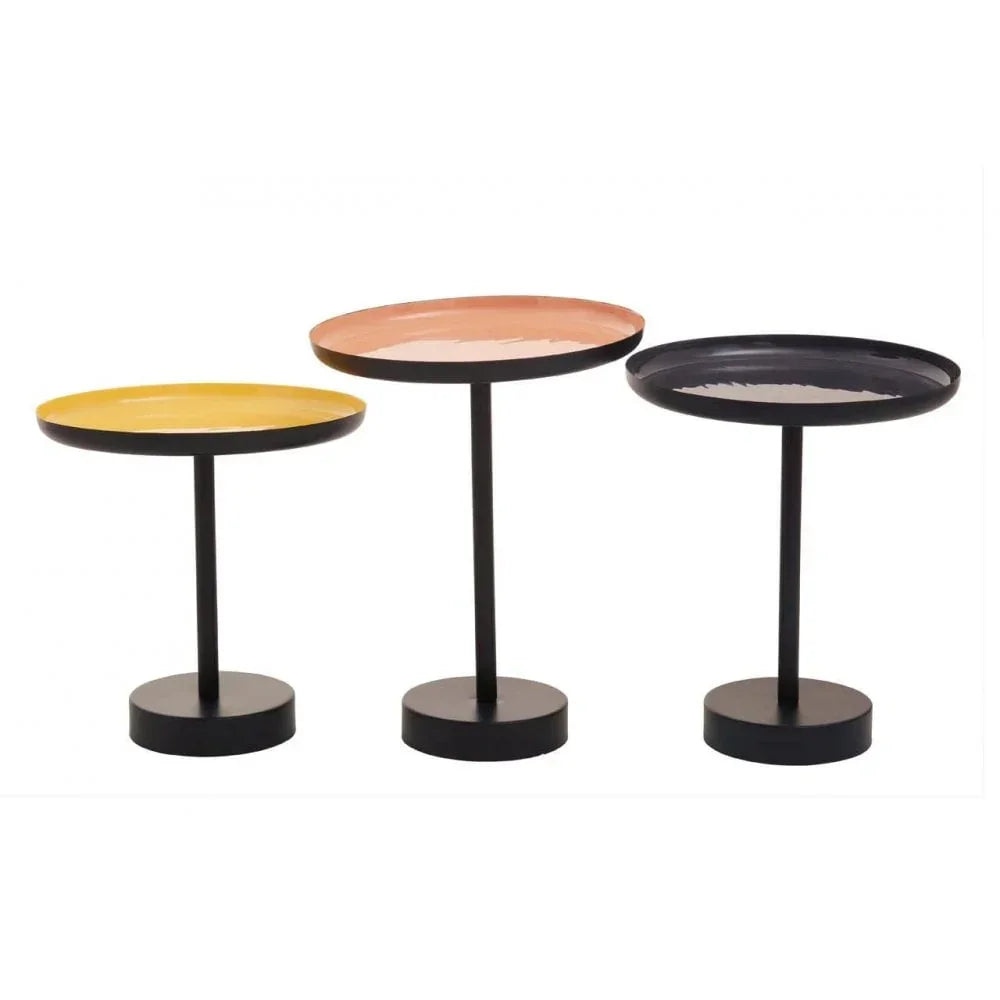 Set of three round metal side tables with yellow, pink, and black tops on black bases