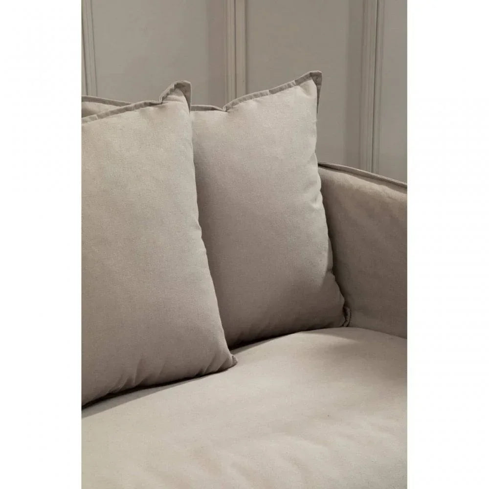 Close-up of beige fabric sofa cushions against a neutral wall