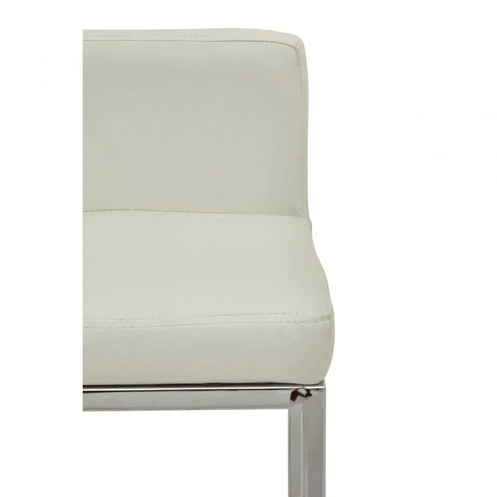 Close-up of cream dining chair with chrome frame and faux leather upholstery