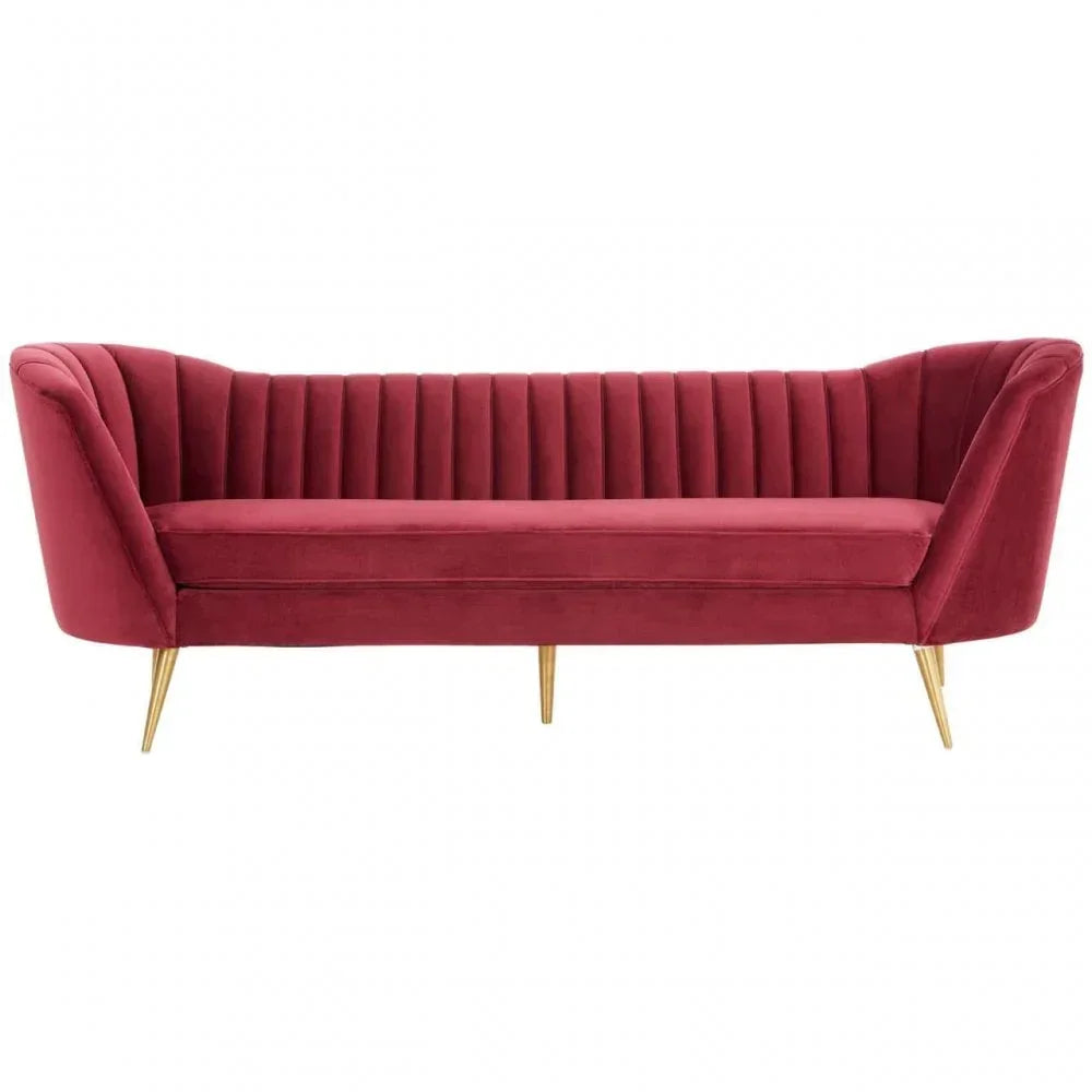 Red velvet sofa with vertical channel tufting and gold metal legs
