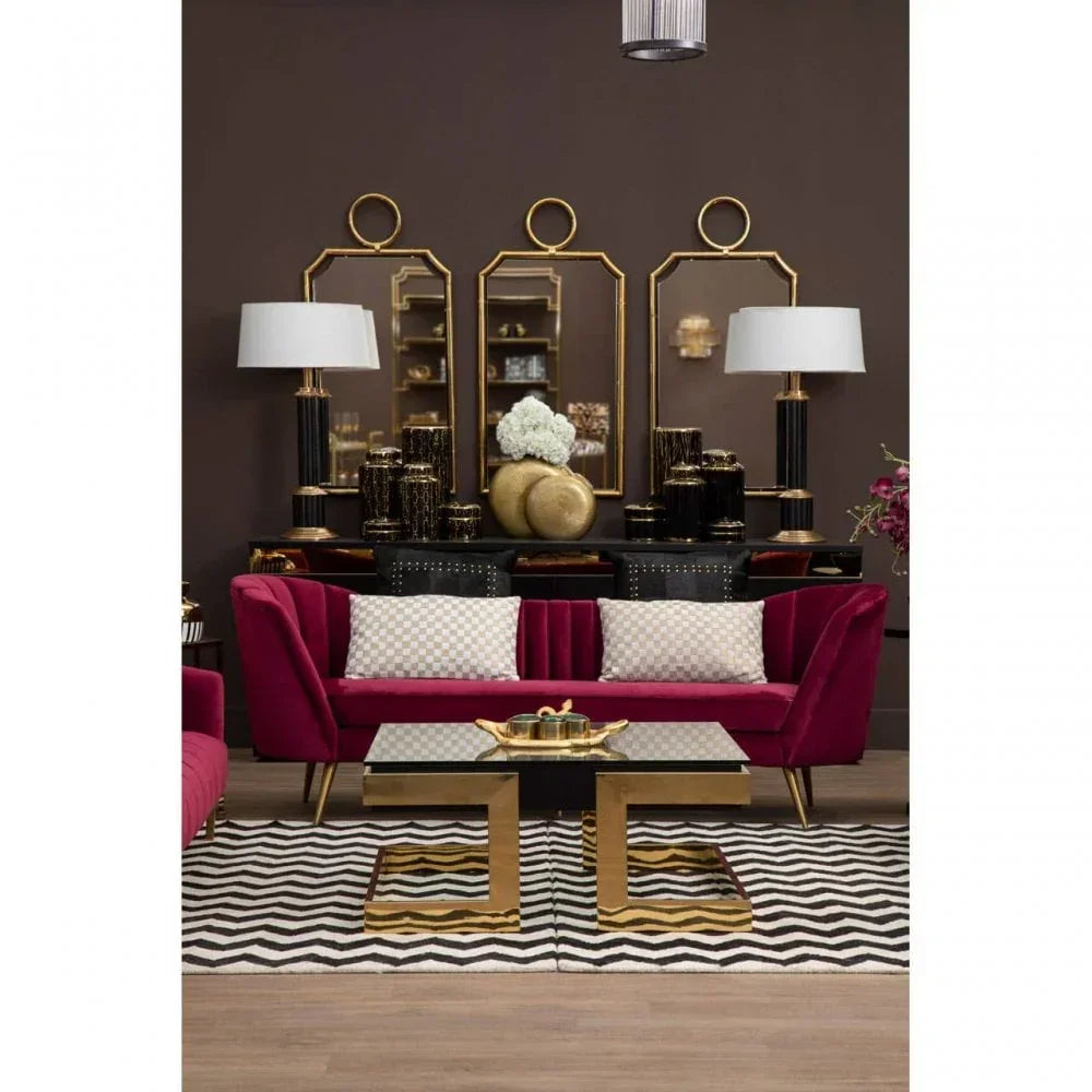 Modern living room with velvet sofa, gold coffee table, mirrors, and black table lamps