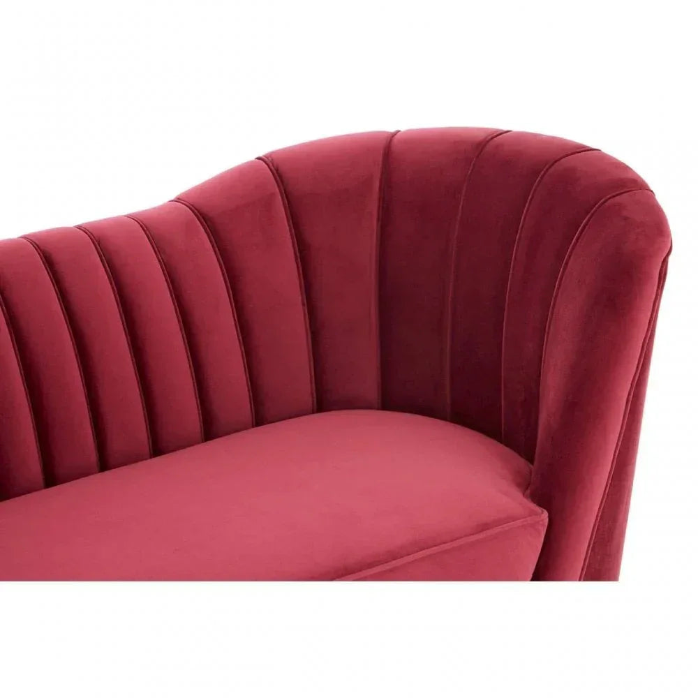 Red velvet sofa with scalloped backrest and vertical channel stitching detail