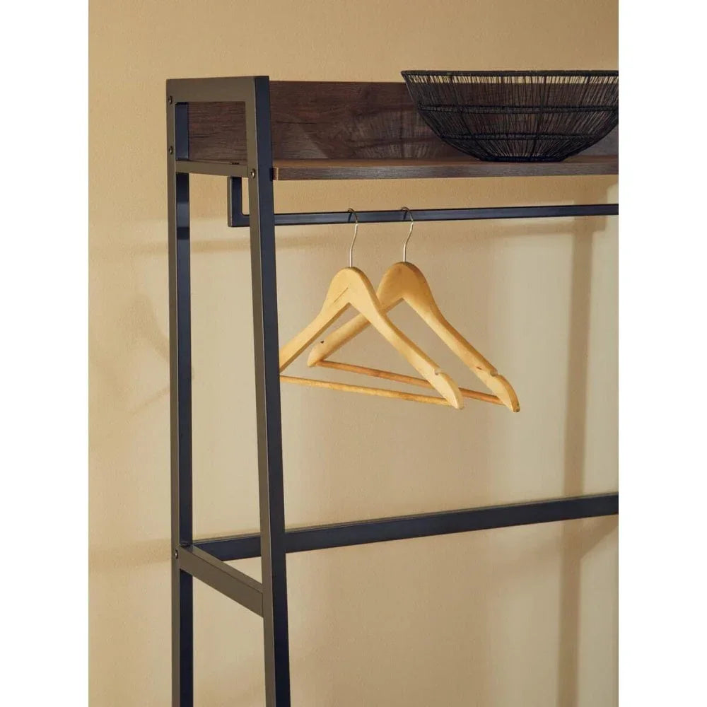 Black metal clothes rail with wooden hangers and a decorative basket on wooden shelf
