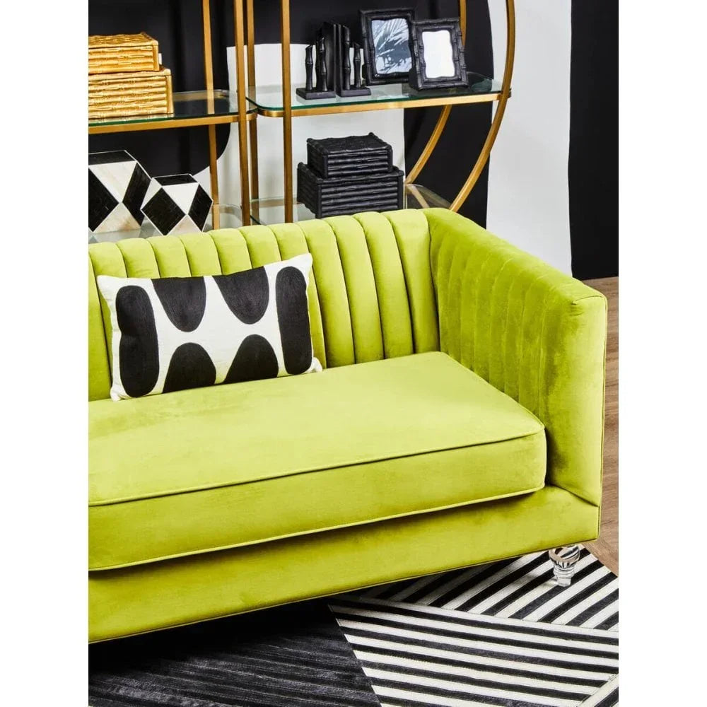 Green velvet sofa with vertical channel tufting and monochrome cushion, modern living room