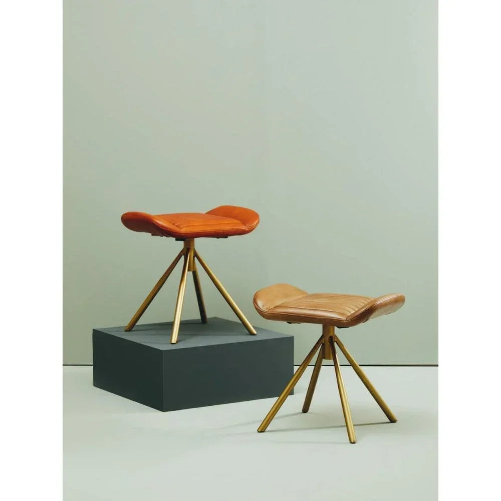 Brown leather stools with gold tripod legs on light grey background
